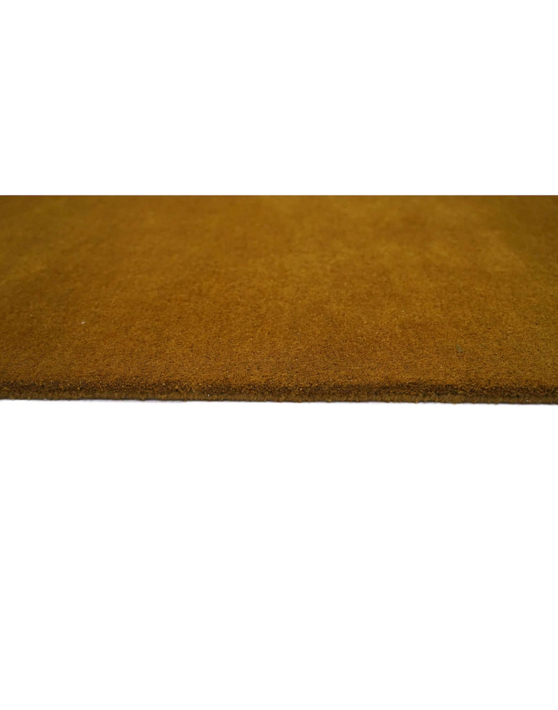 I C O N - O C H R E rug close-up showing rich ochre color and dense tufted texture.